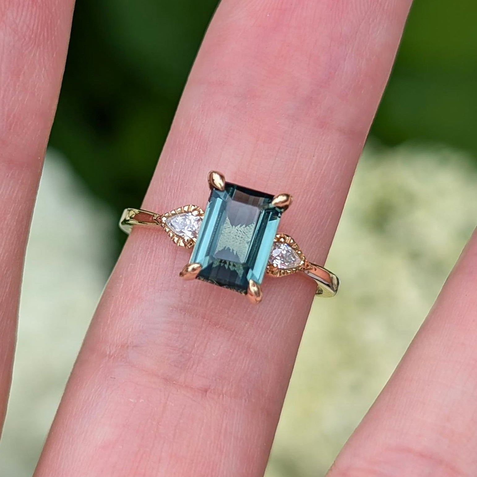 Verlobungsring mit smaragdgeschliffenem, grünem Edelstein und Blattmotiv