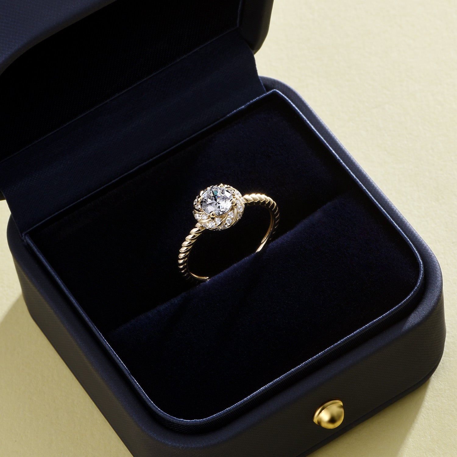 Bague de fiançailles Dissoo® en or jaune, sertie d'un halo torsadé et d'une moissanite.